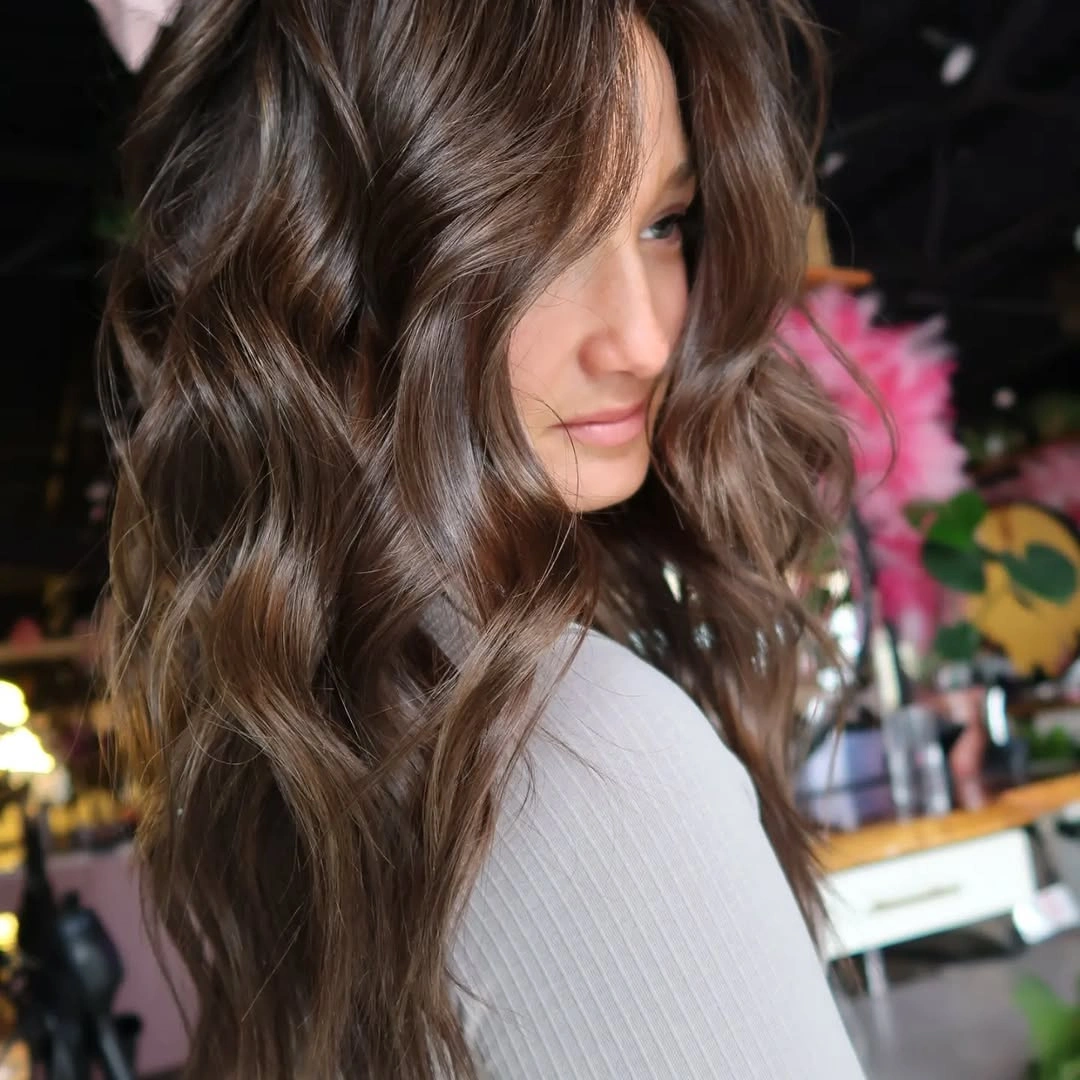 Medium-to-long wavy cool brown hair from front side view