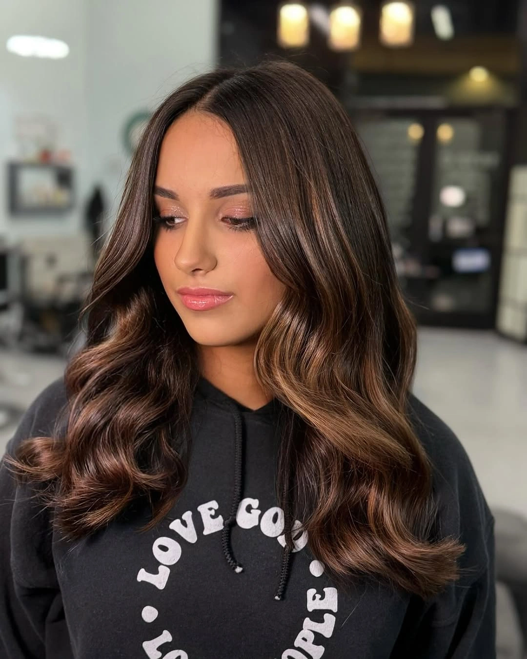 Dark brunette wavy hair with a center part and front layers
