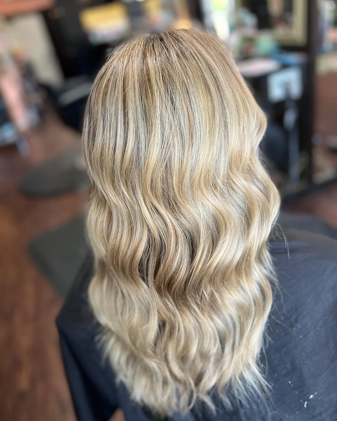 Layered light wavy hair of medium-to-long length seen from the back