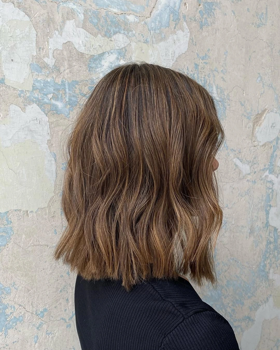 Wavy brunette shoulder-length lob with a soft angled edge