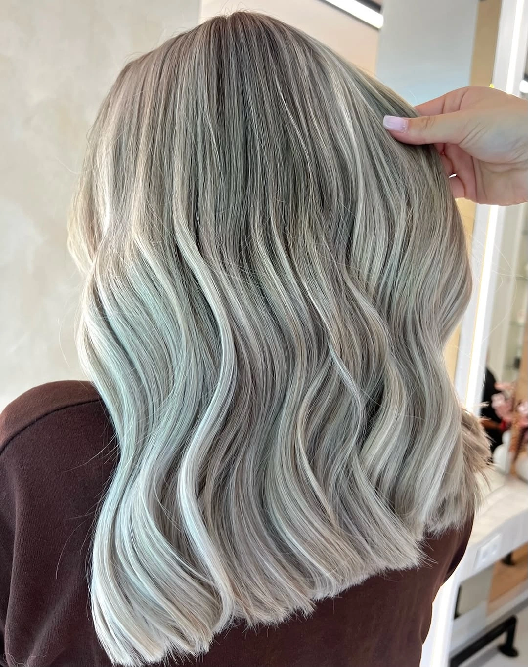 Wavy ash-light shoulder-length hair with a lifted layer and even ends
