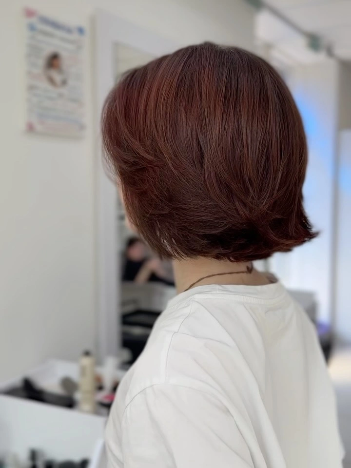 Short auburn bob with rounded crown and flipped nape