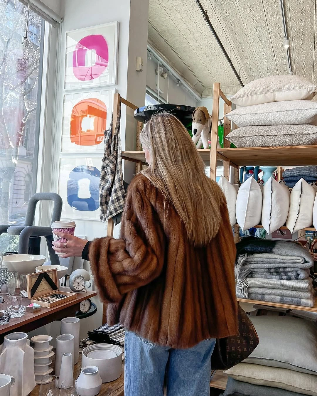 Back view in brown fur-looking jacket and light blue jeans