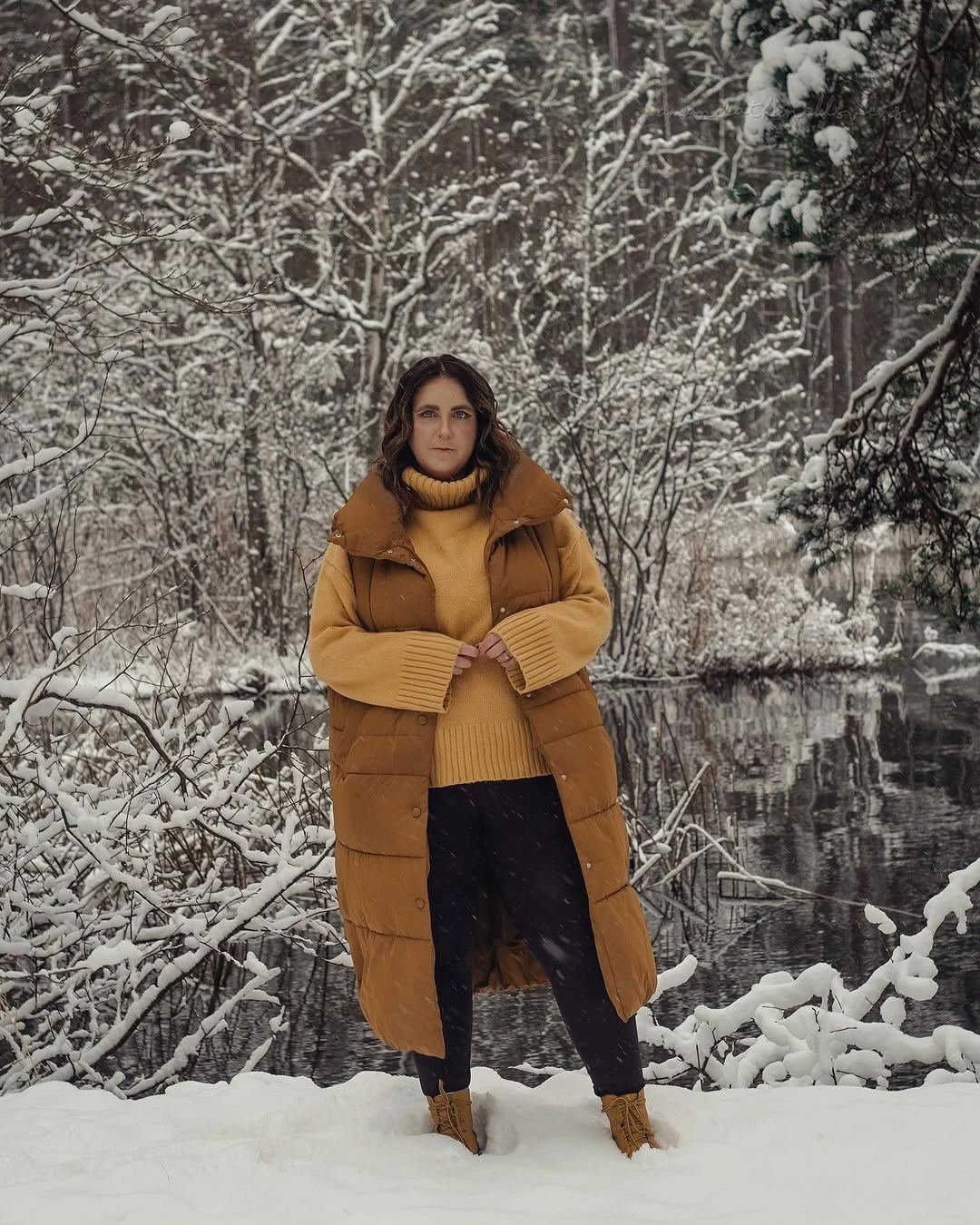 Golden-brown puffer vest, mustard sweater, black pants and tan boots