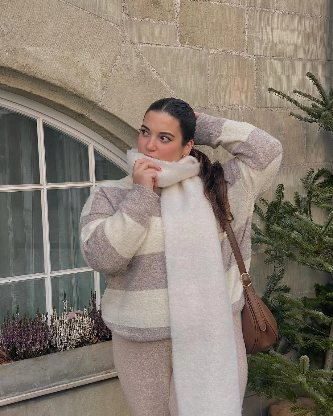 Striped neutral sweater with cream scarf and brown shoulder bag