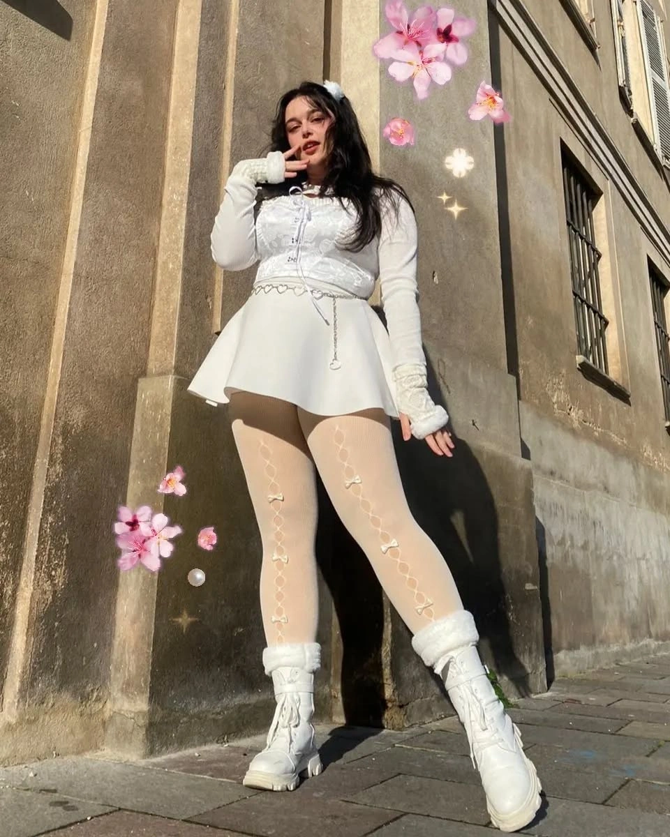 White fitted layers, flared skirt shape, patterned tights and boots