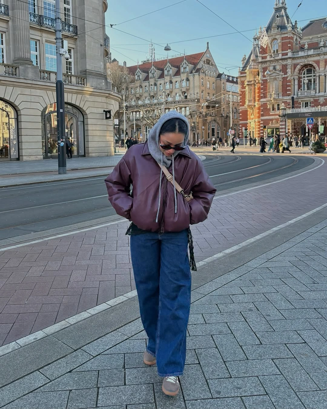 Burgundy leather-look jacket with gray hood and blue jeans