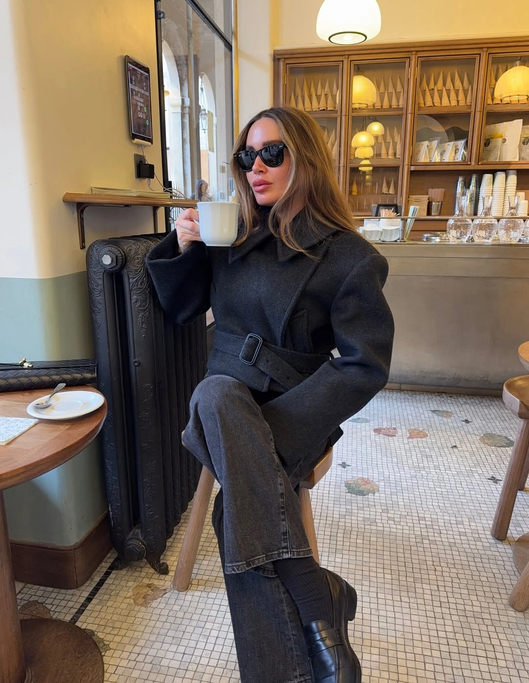 Dark belted layer with gray trousers and black boots