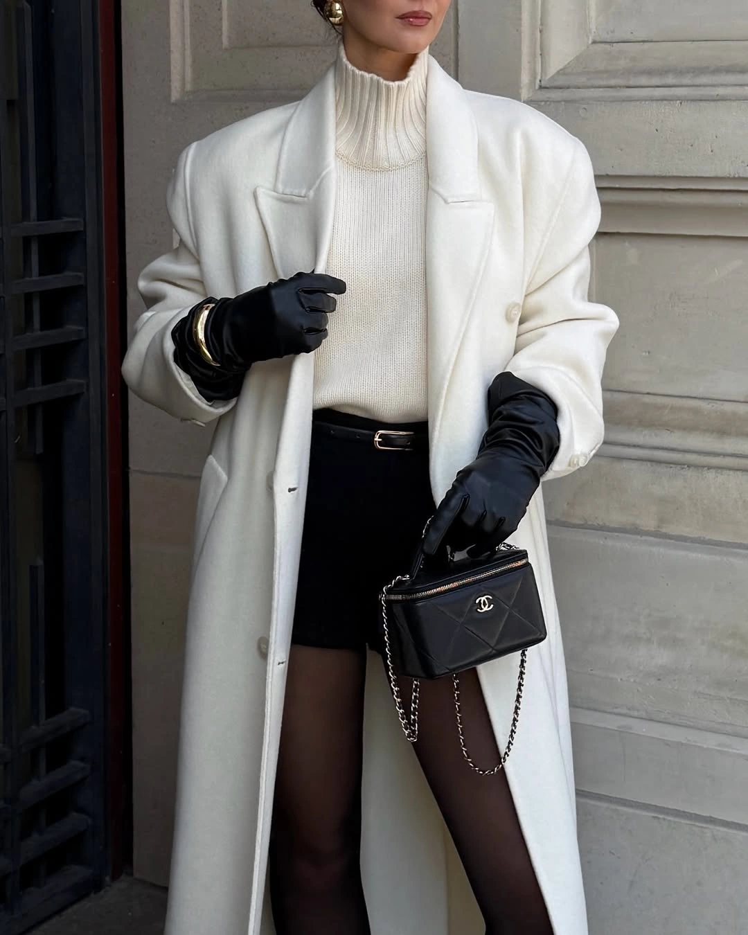 Long white coat with cream turtleneck and black tights