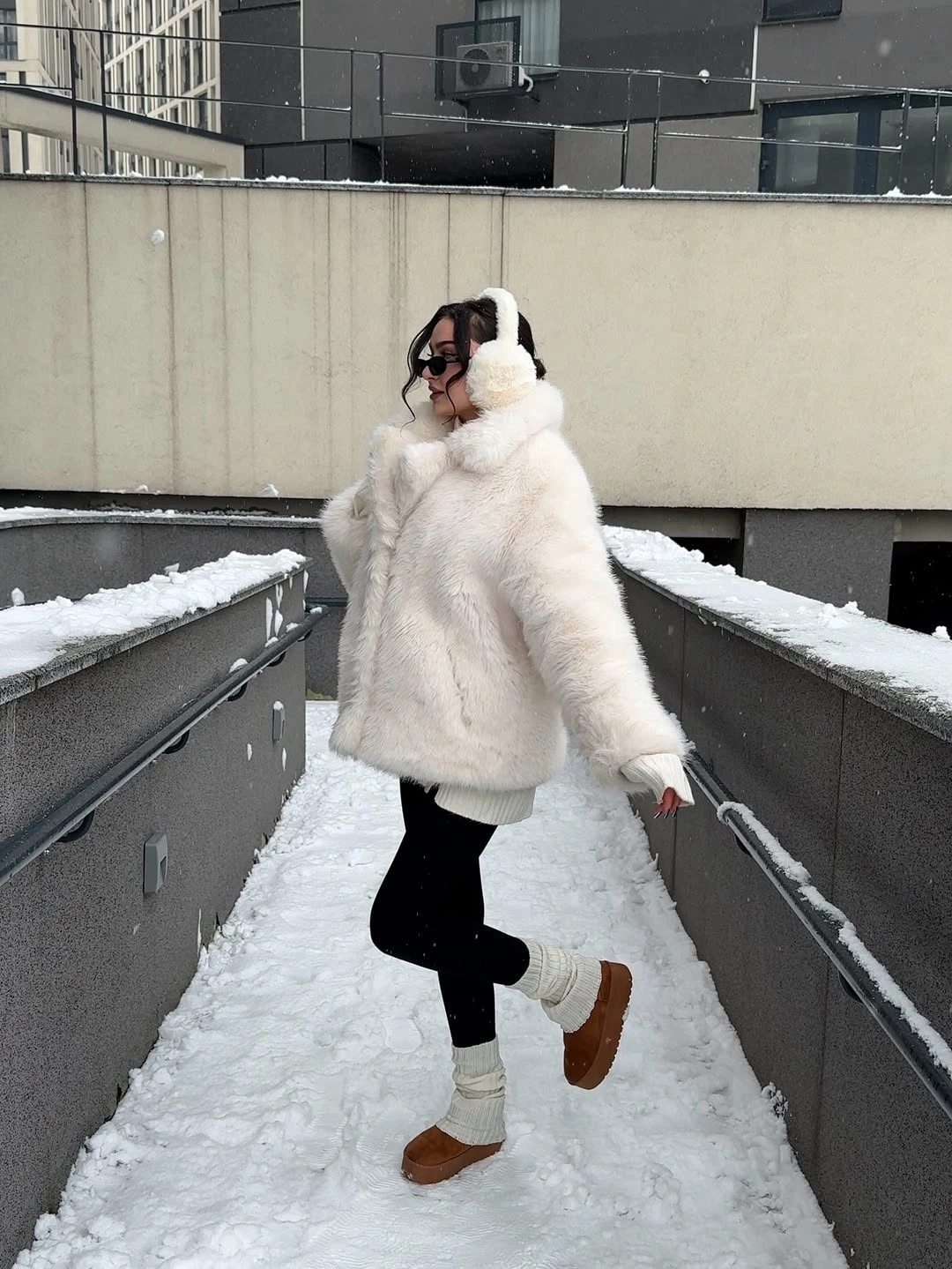 White plush-looking hooded coat with black lower clothing