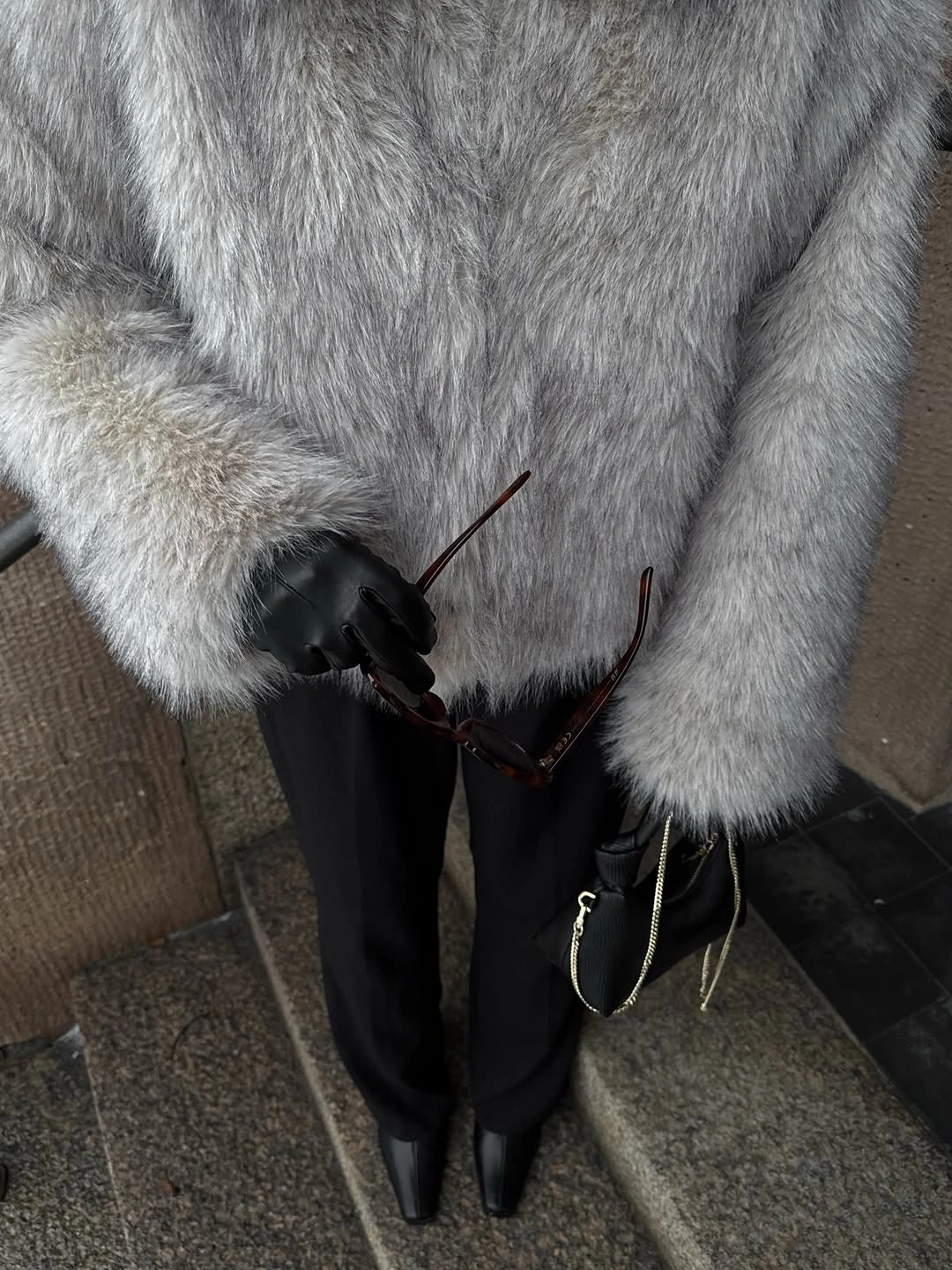 Gray fur-like coat with black gloves and trousers