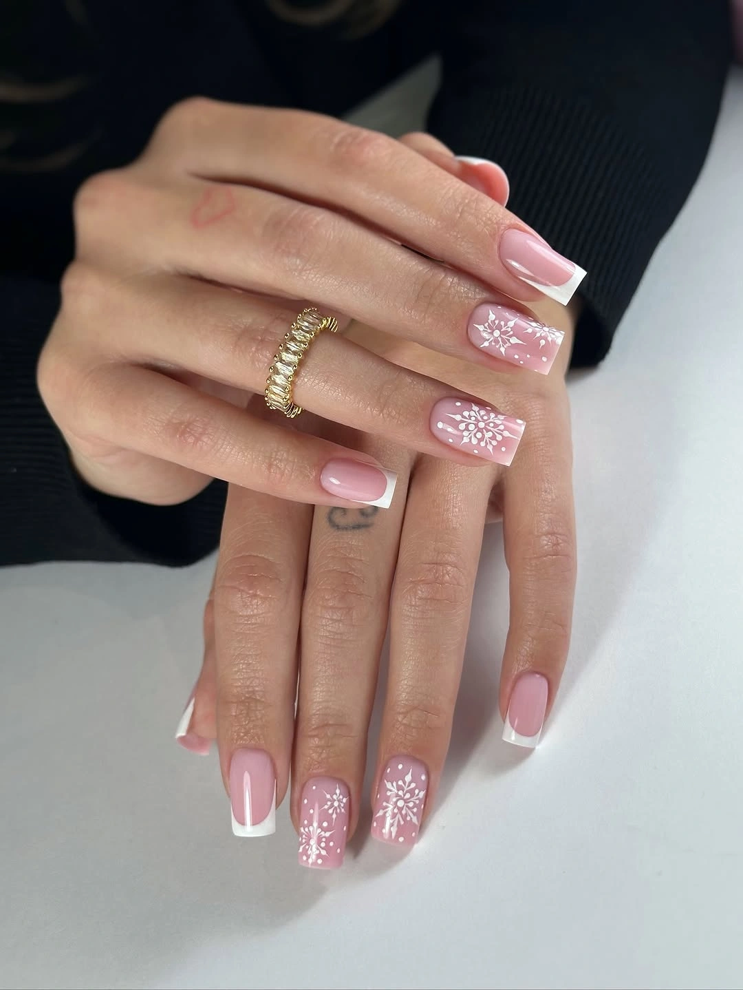 Pale pink square French nails with white snowflake accents