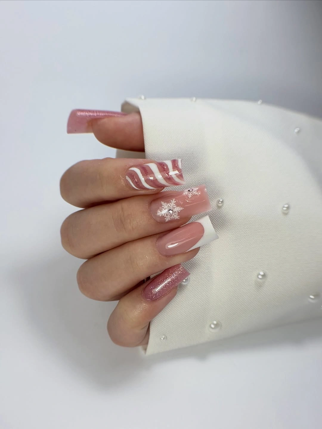 Pink square nails with white French tip, stripe and snowflake