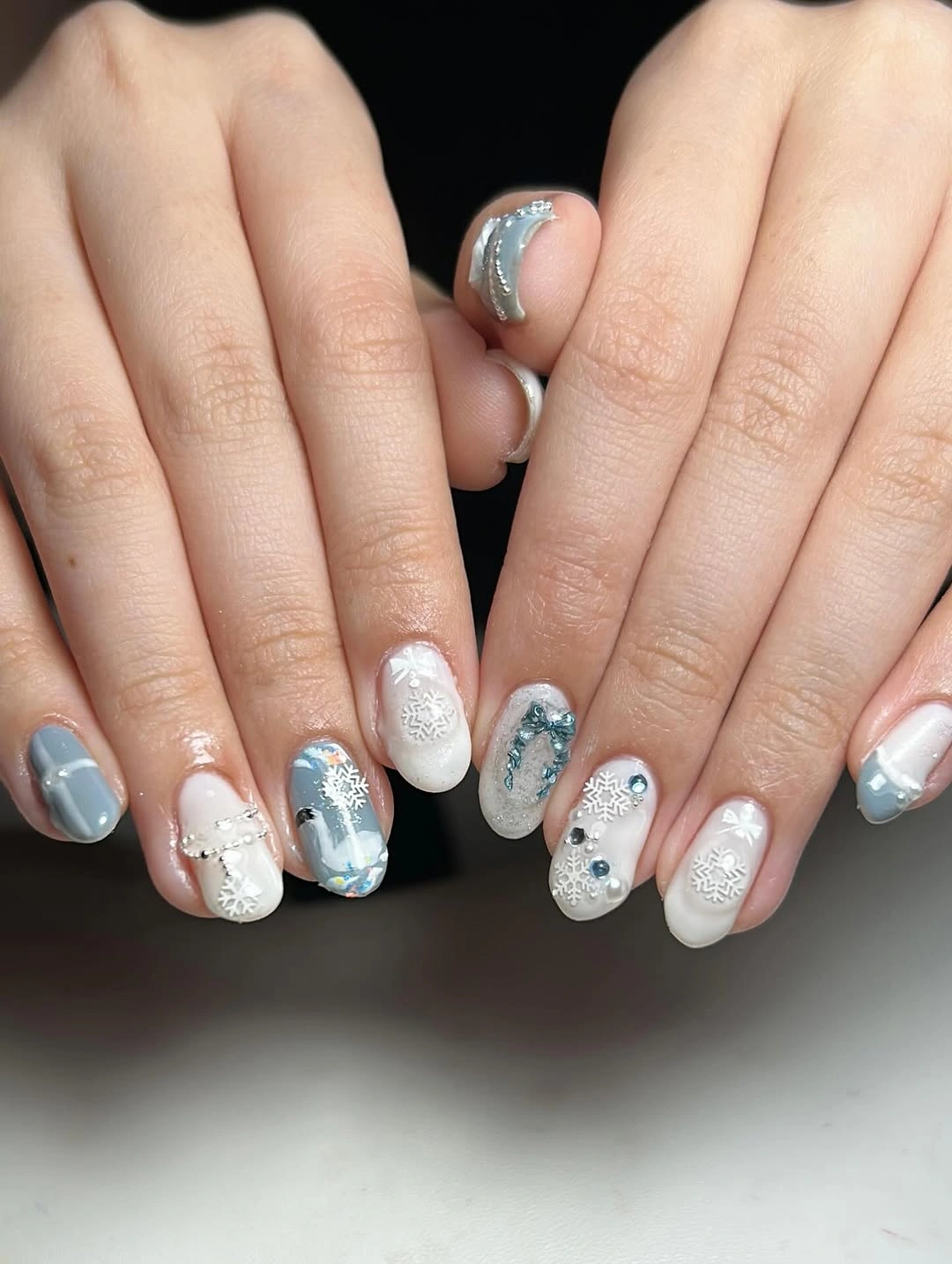 Short rounded blue-gray and white nails with snowflakes