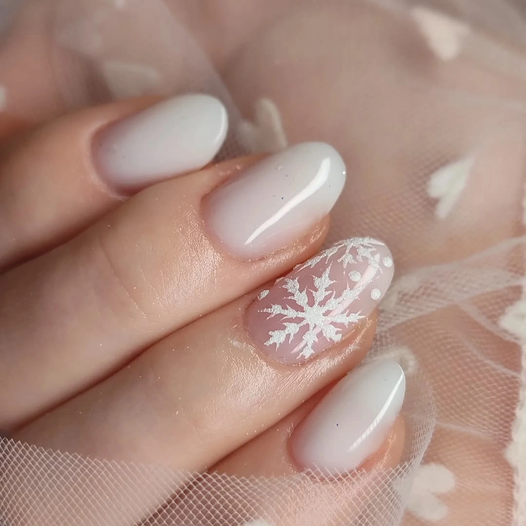 Short milky white oval nails with sheer snowflake accent
