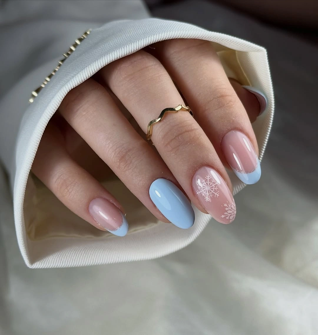Pale pink almond nails with baby blue tips and snowflake