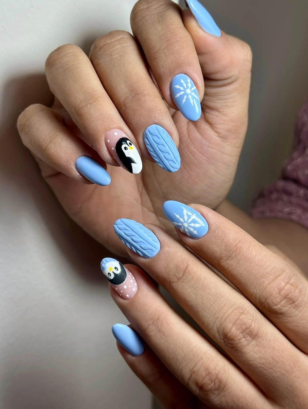Blue almond nails with penguins, snowflakes and raised texture