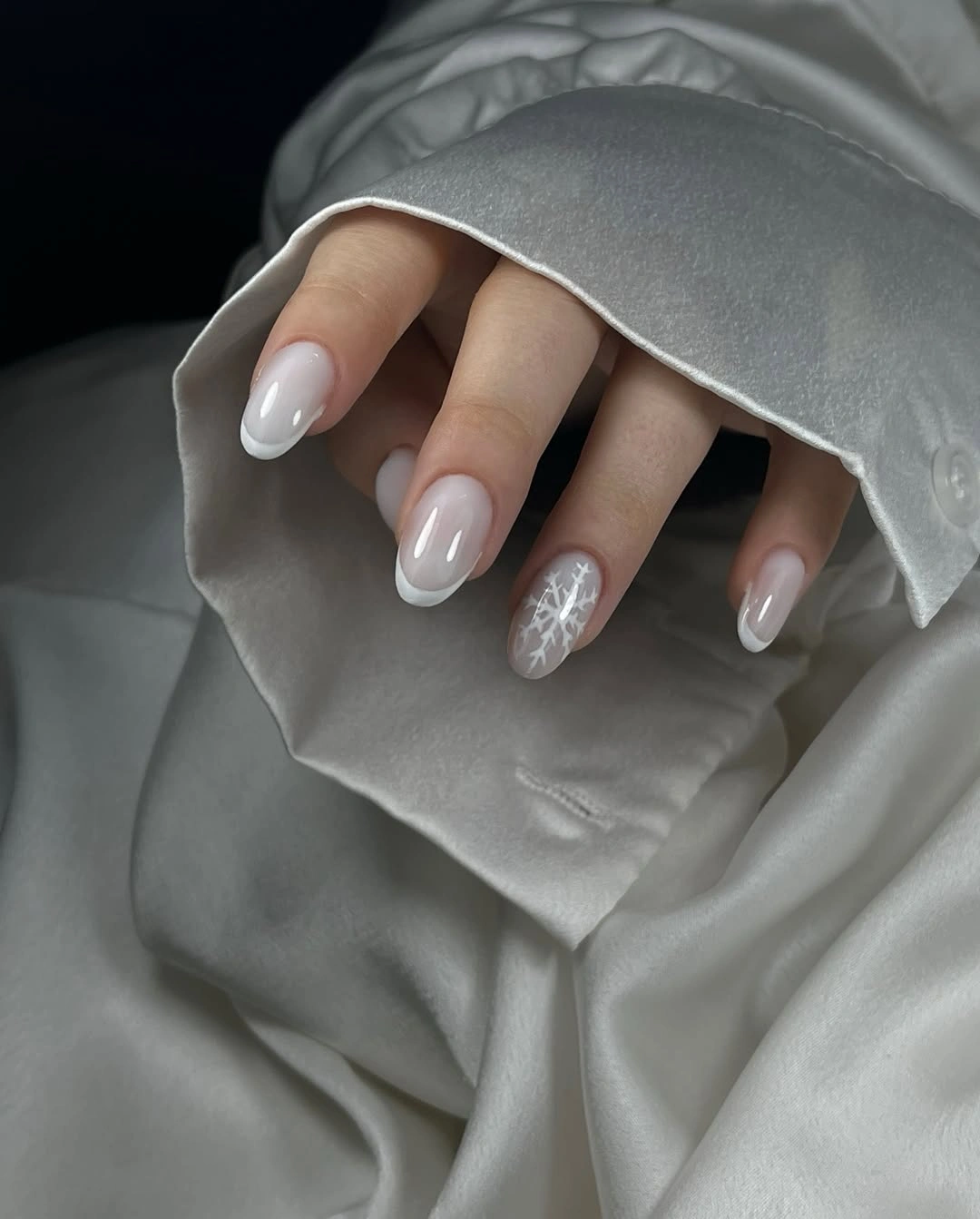 Milky almond nails with white tips and snowflake accent