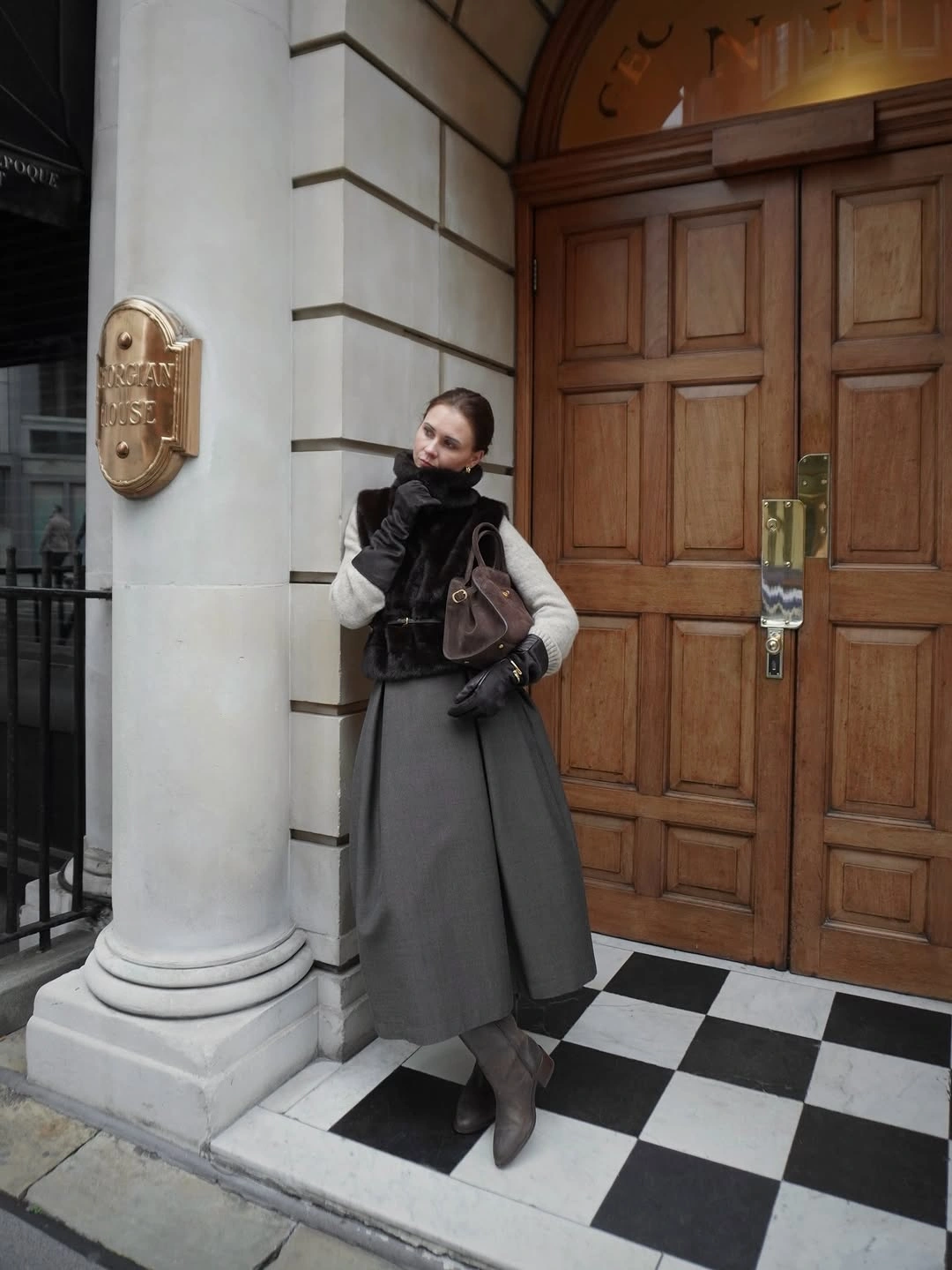 Textured-looking vest over gray midi skirt with gray boots