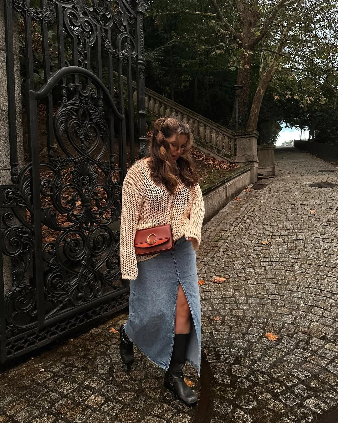 Open-knit-looking cardigan with blue front-slit denim skirt and black boots