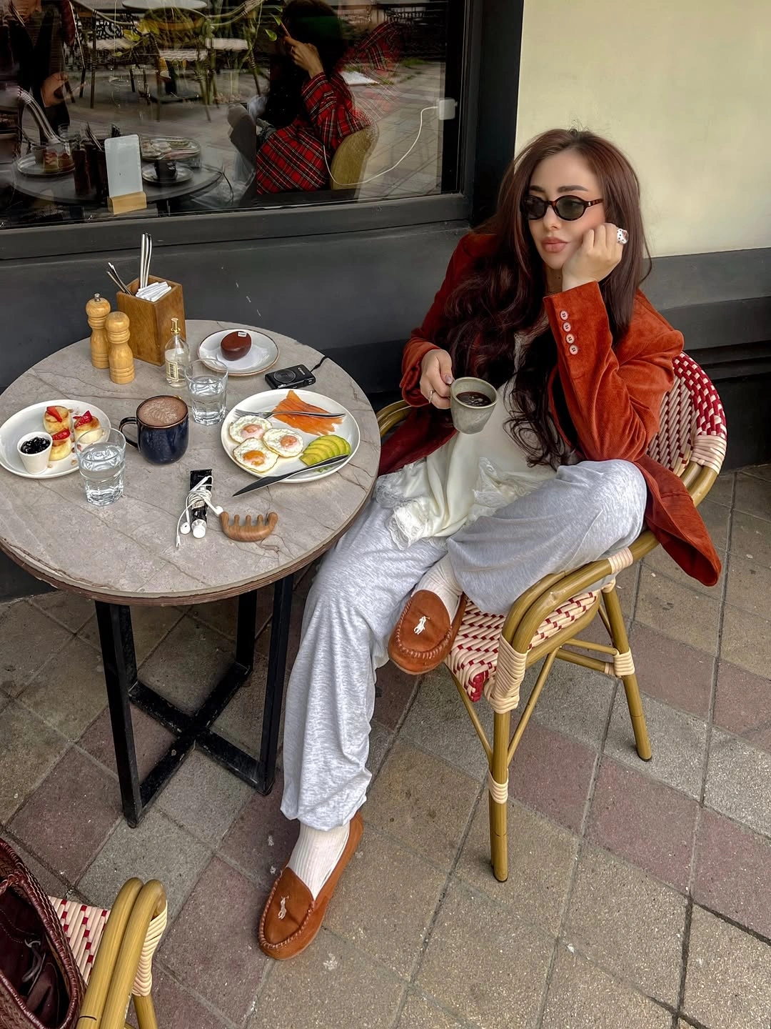 Rust orange jacket with pale gray cuffed trousers and brown loafers