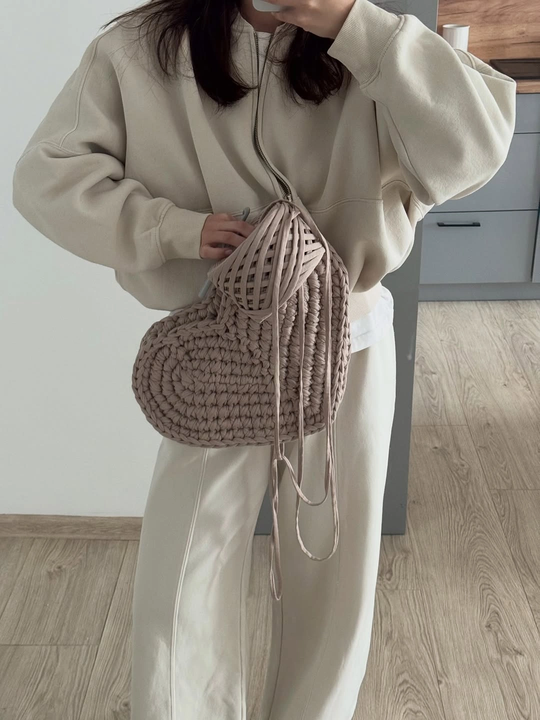 Oversized cream hoodie and loose trousers with taupe woven bag