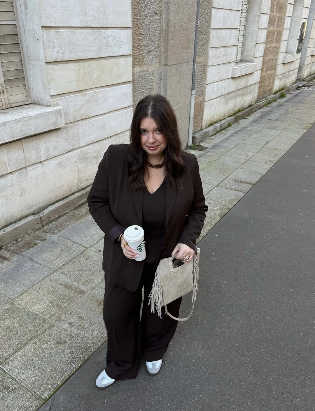 Black blazer and trousers with light fringed bag and sneakers