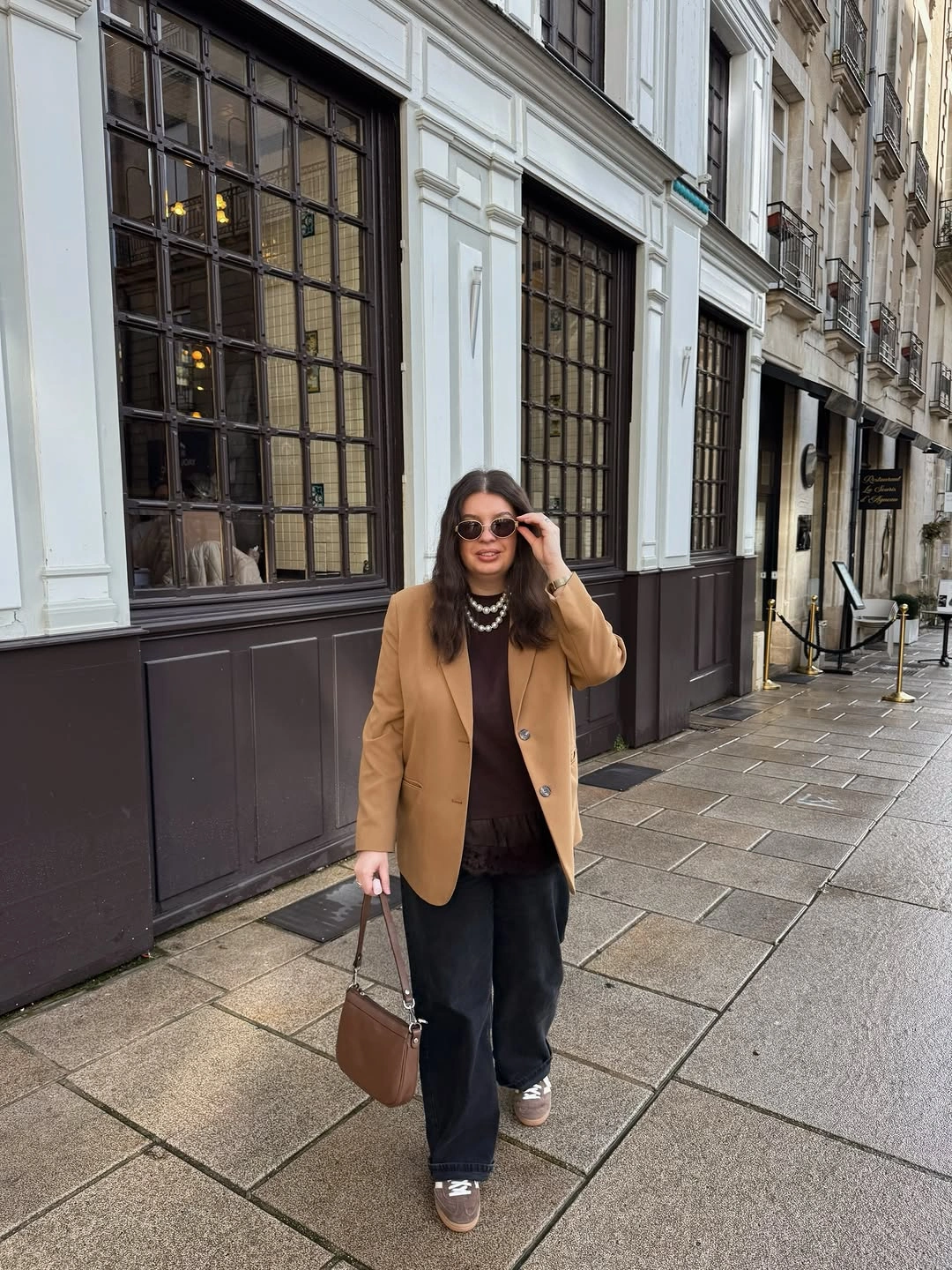 Camel blazer with dark trousers, sneakers and brown handbag