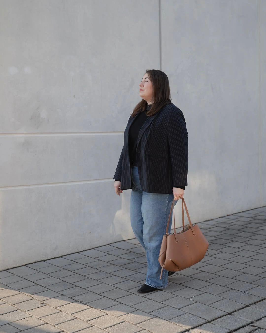 Dark ribbed layer with light jeans and tan tote