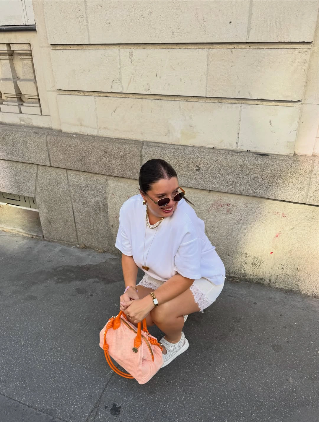 Oversized white top with lace-trim layer and peach bag
