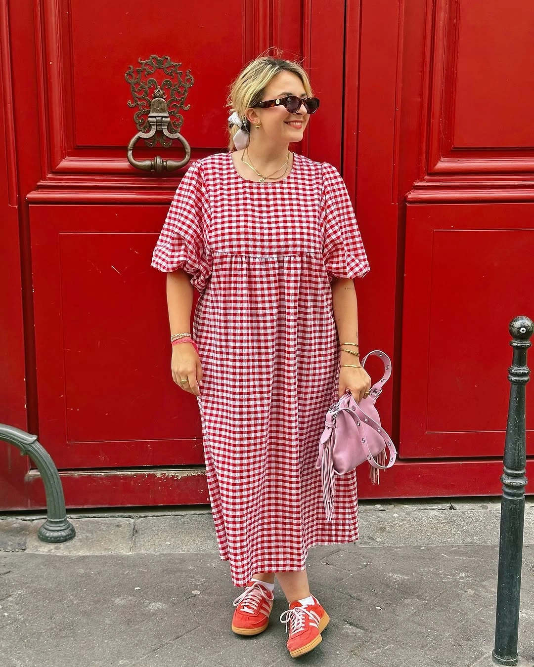 Red gingham midi dress with sneakers and pink handbag