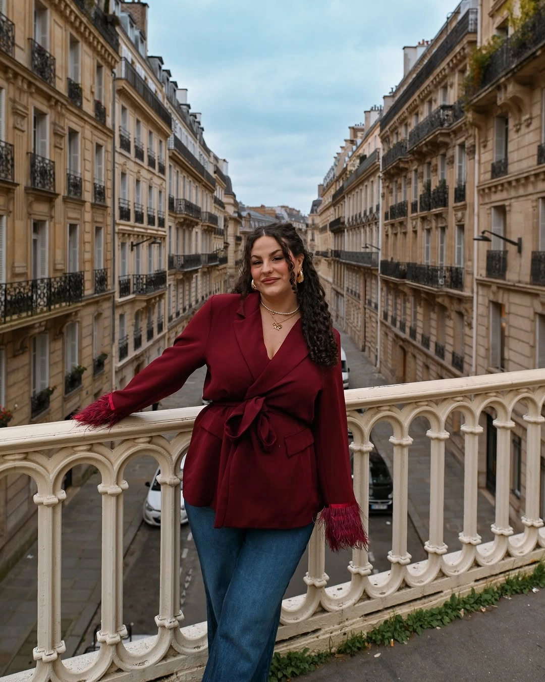 Burgundy belted jacket with fringe cuffs and jeans