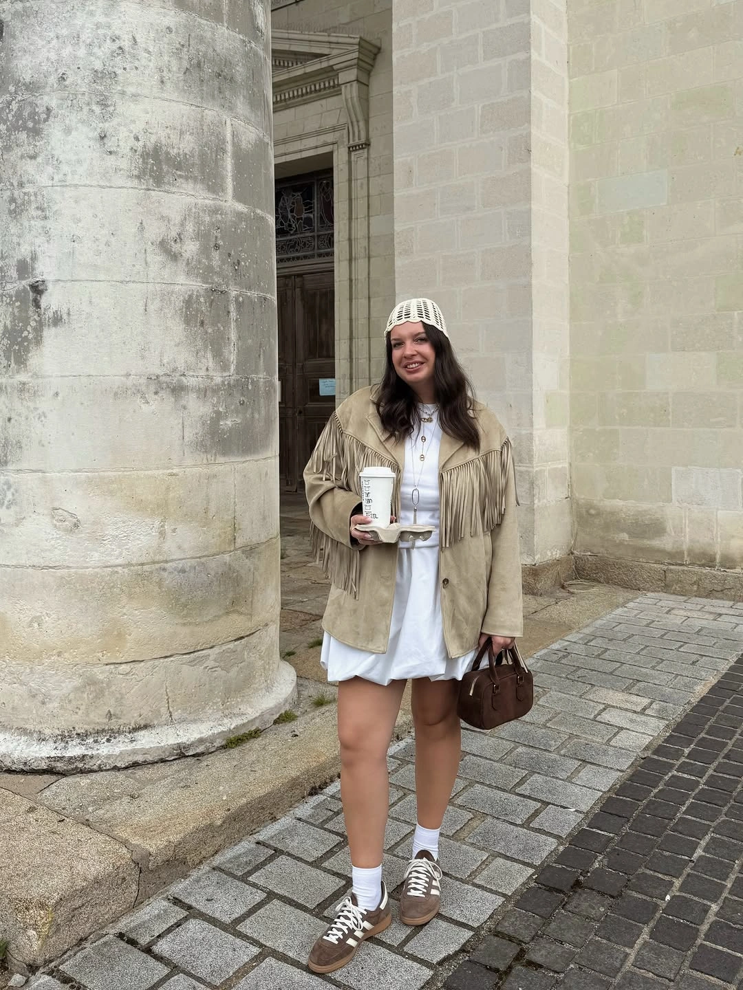 Beige fringed jacket over long white shirting layer