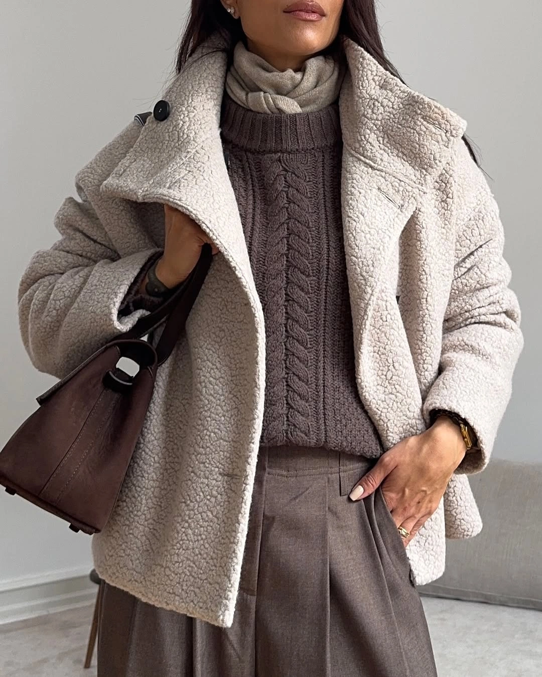 Cream textured jacket with cable sweater and taupe pleated trousers