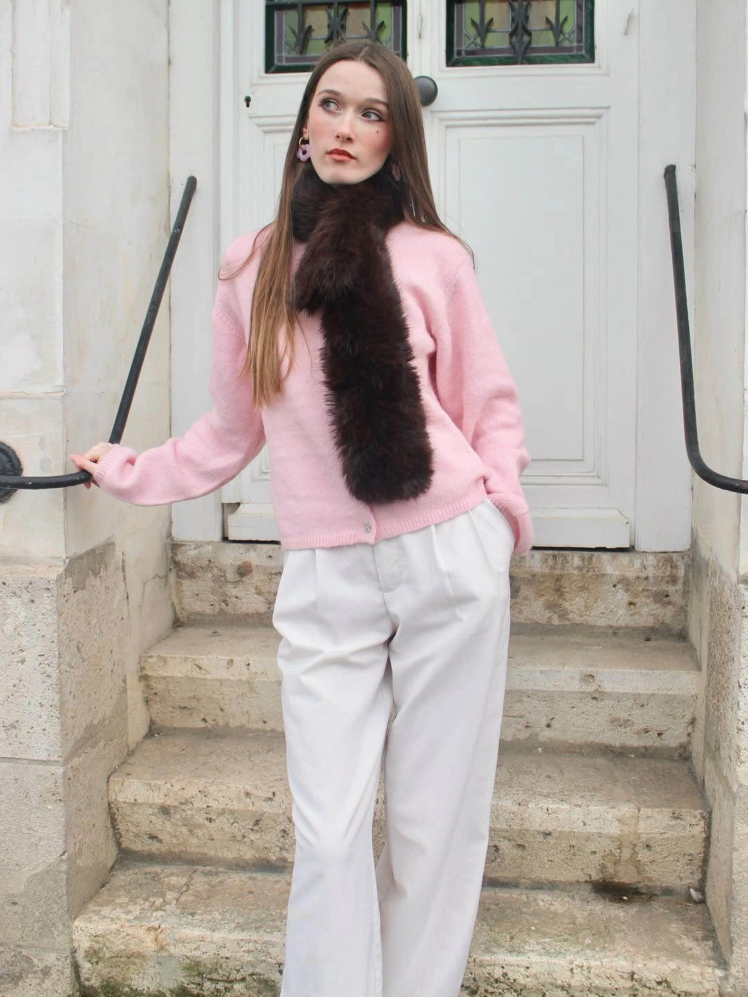 Pink cardigan with dark textured scarf and loose white trousers