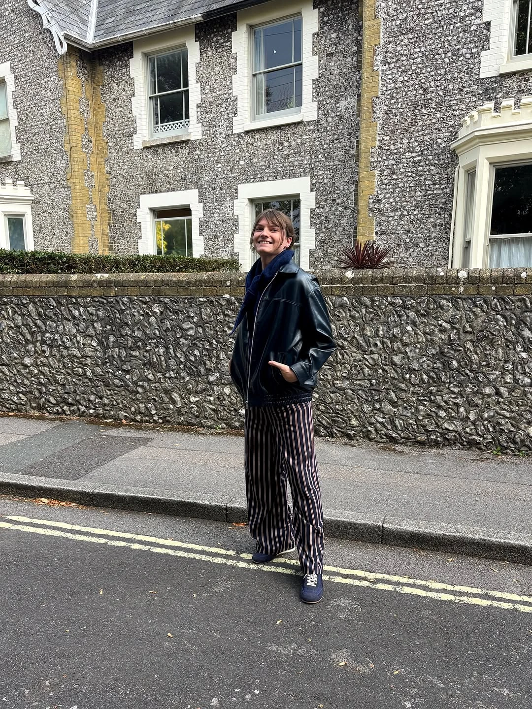 Black jacket with striped wide-leg trousers and blue accents
