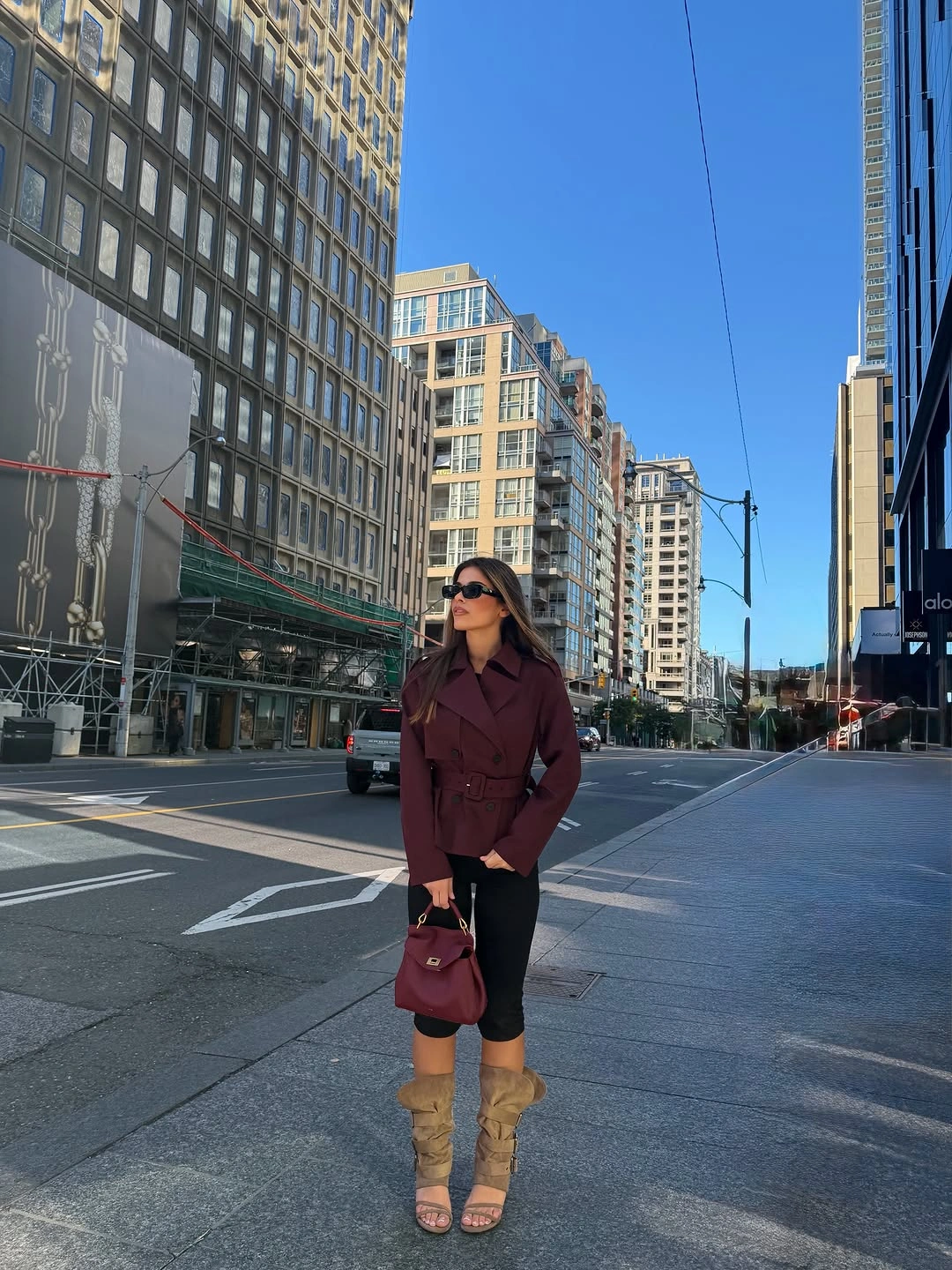 Burgundy jacket with cropped black trousers and tall tan footwear