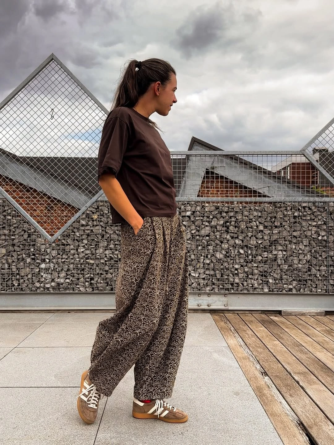 Dark brown T-shirt with printed loose trousers and sneakers
