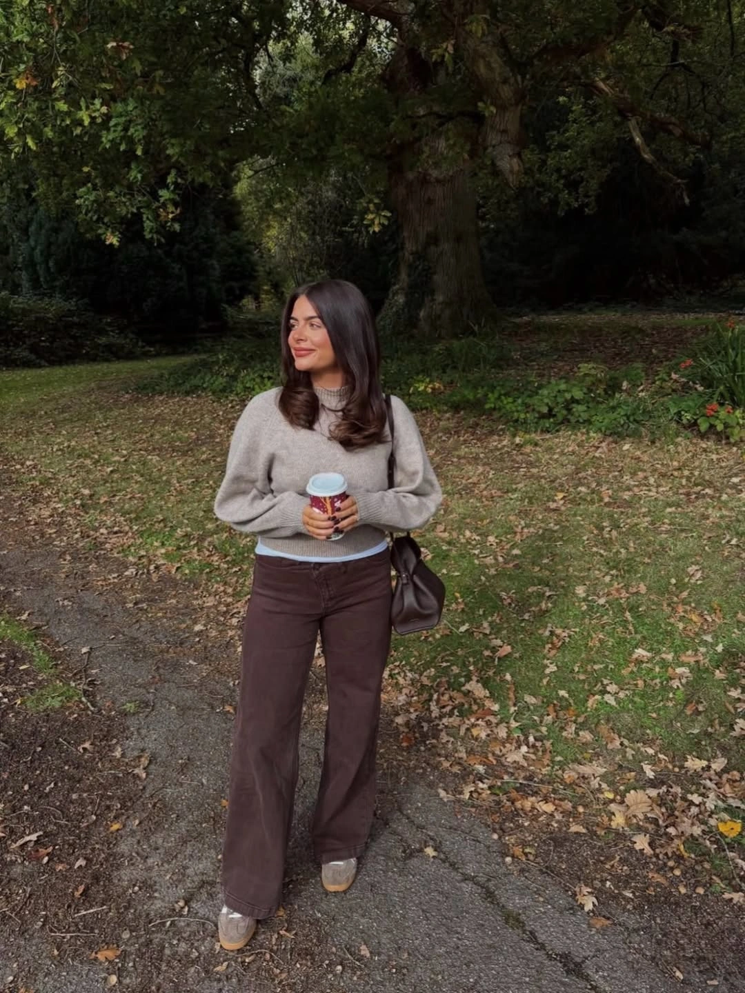 Gray sweater with brown trousers and dark shoulder bag