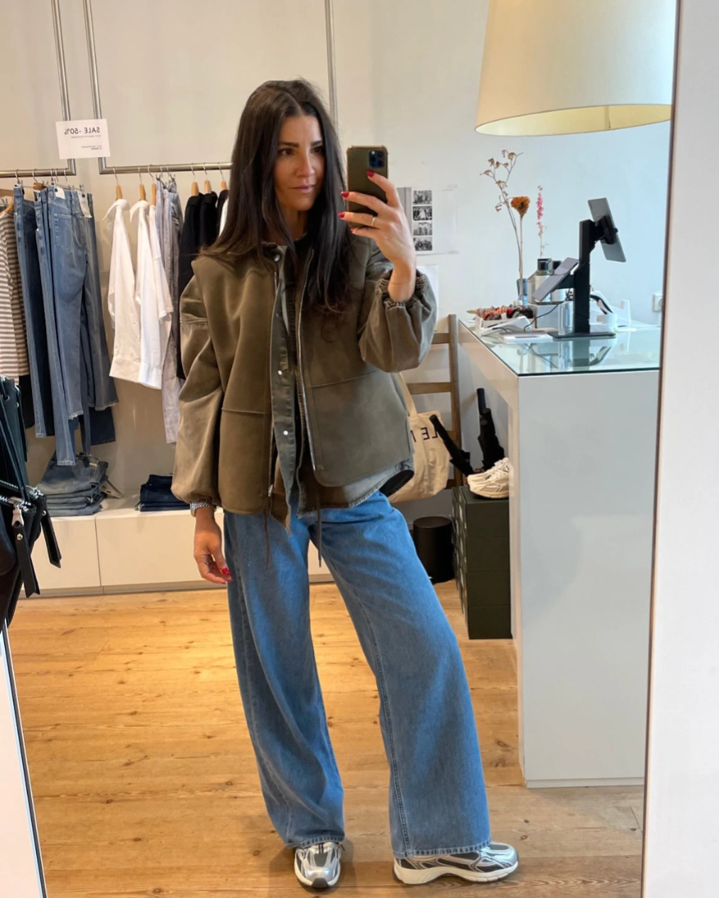 Olive cropped jacket with wide jeans and metallic sneakers