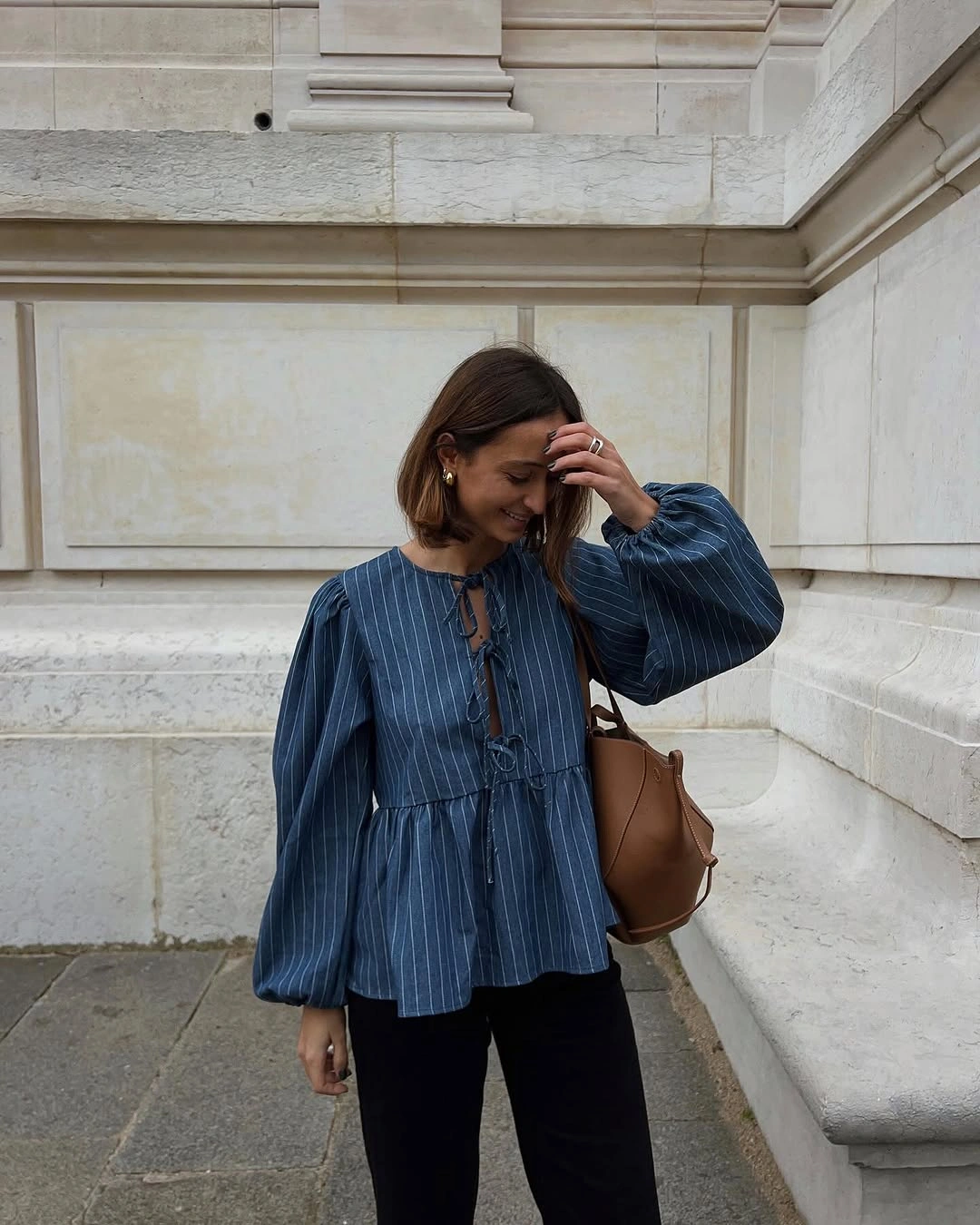 Blue striped blouse with front ties, voluminous sleeves, and black trousers