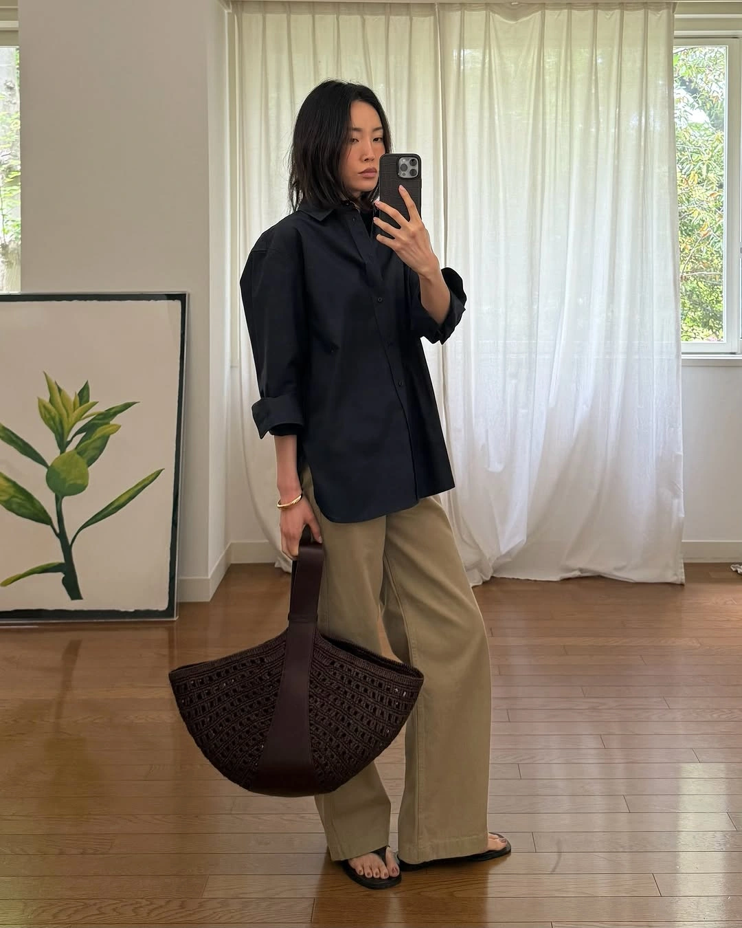 Oversized navy shirt with khaki wide trousers and brown open-weave tote