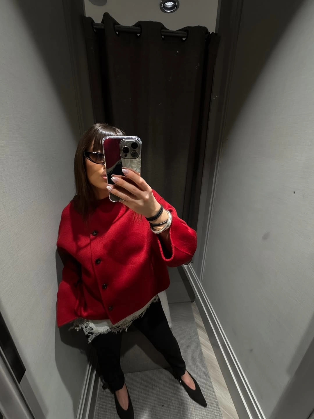 Cropped red button-front jacket with black legwear and dark pointed shoes