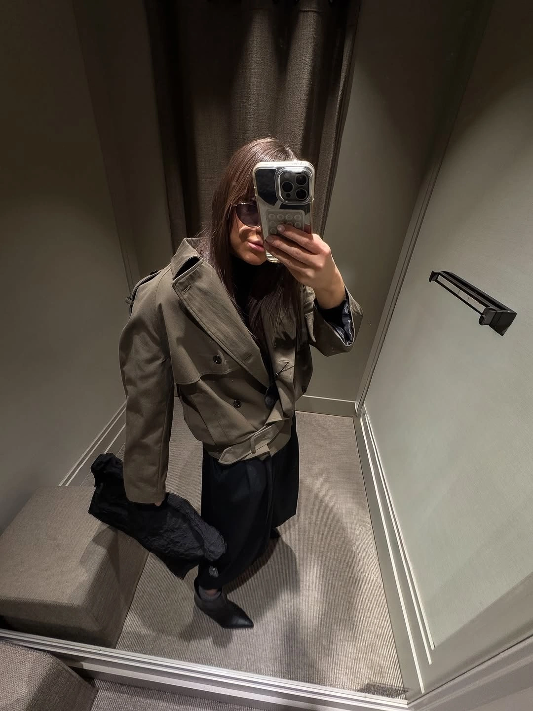 Belted olive-gray double-breasted jacket with short black layer and pointed footwear