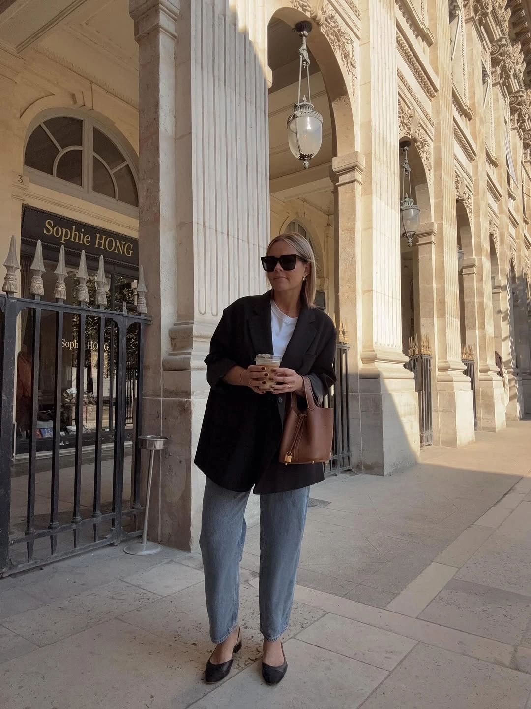 Oversized black blazer over white top with blue jeans and pointed flats