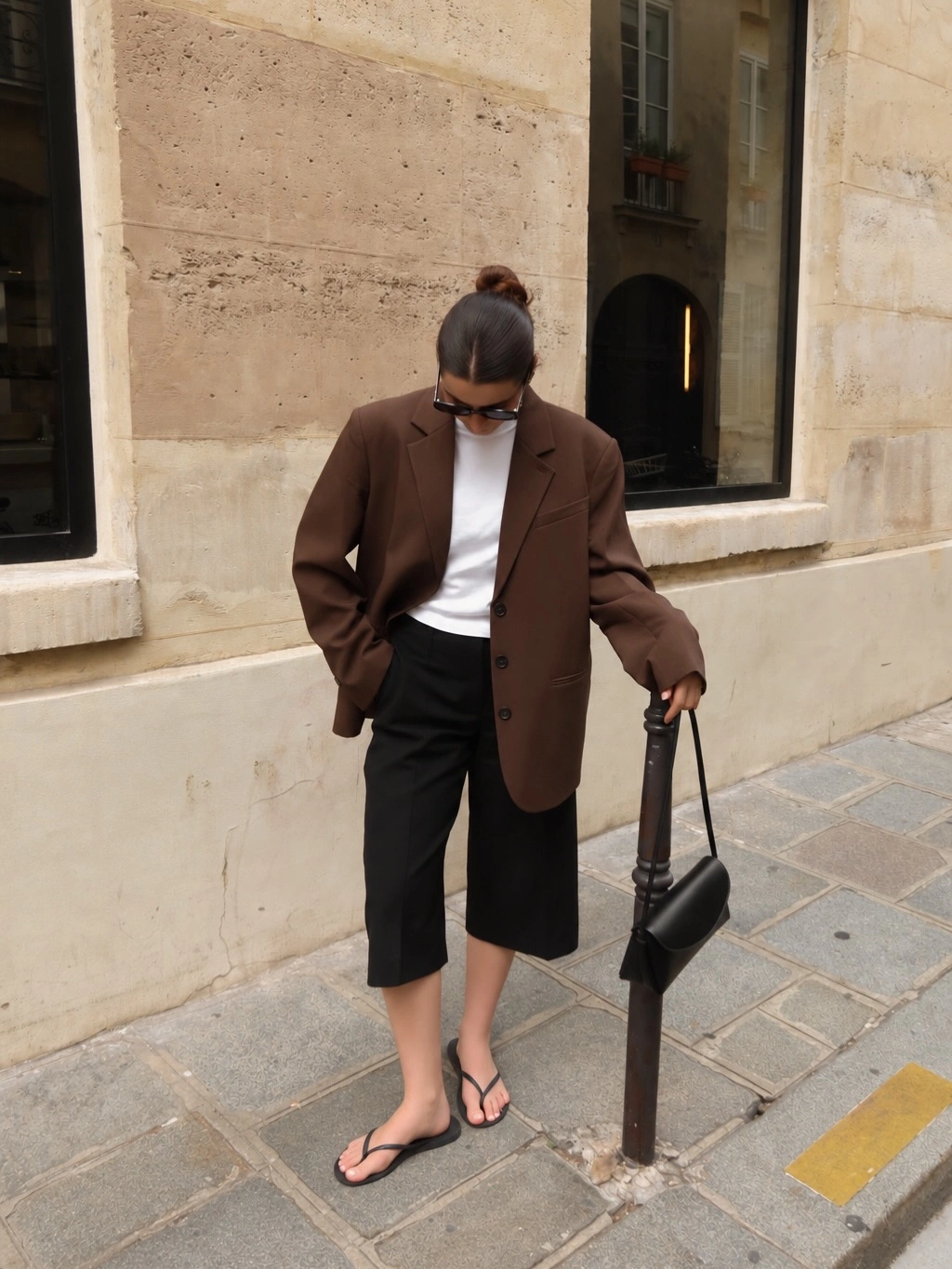 Brown oversized blazer with white T-shirt, black long shorts, and flip-flops