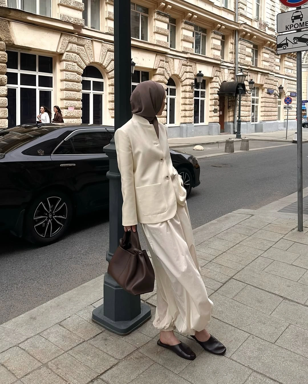 Cream blazer and flowing cream lower garment with brown headscarf and handbag