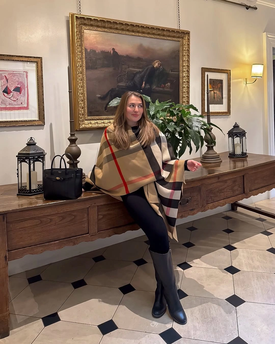 Camel plaid wrap over dark trousers with tall black boots