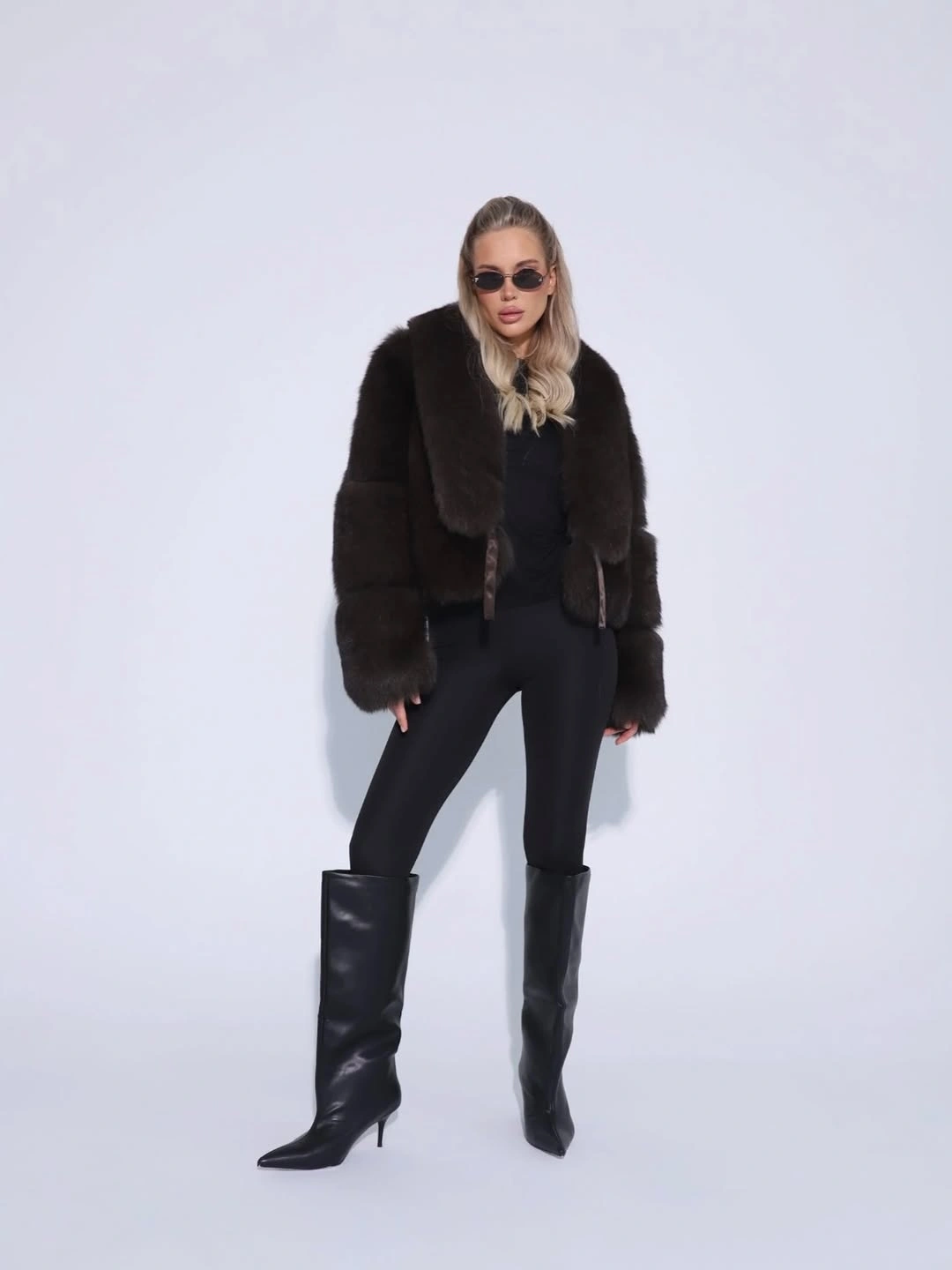 Short dark brown plush jacket, fitted black pants, and tall pointed boots
