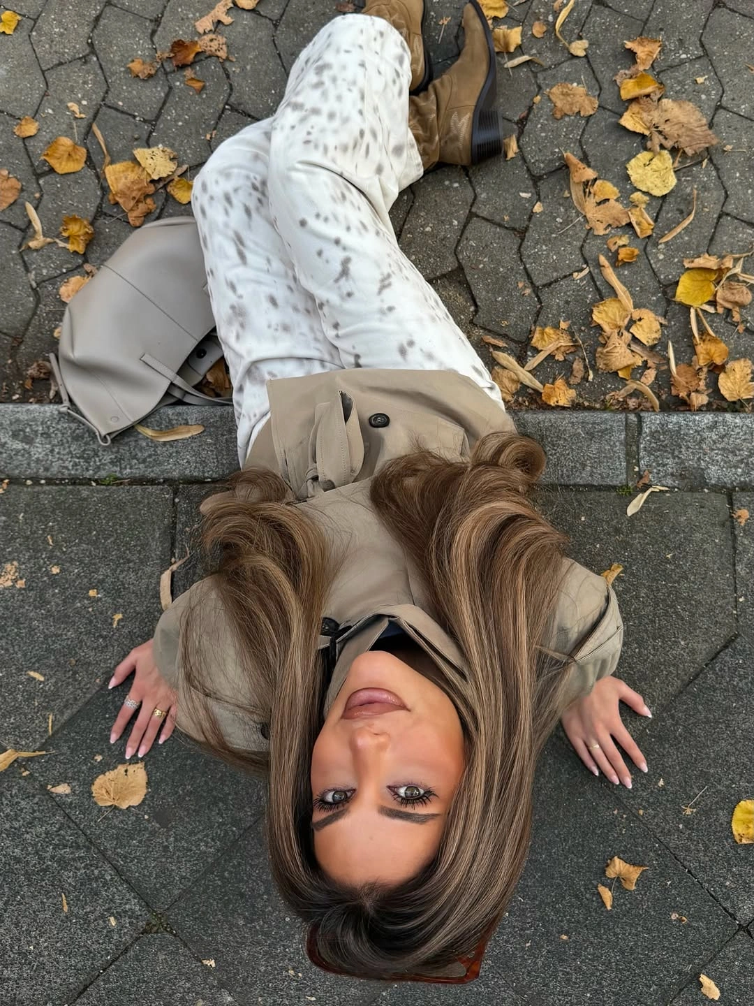 Taupe outer layer with gray patterned trousers and structured gray handbag